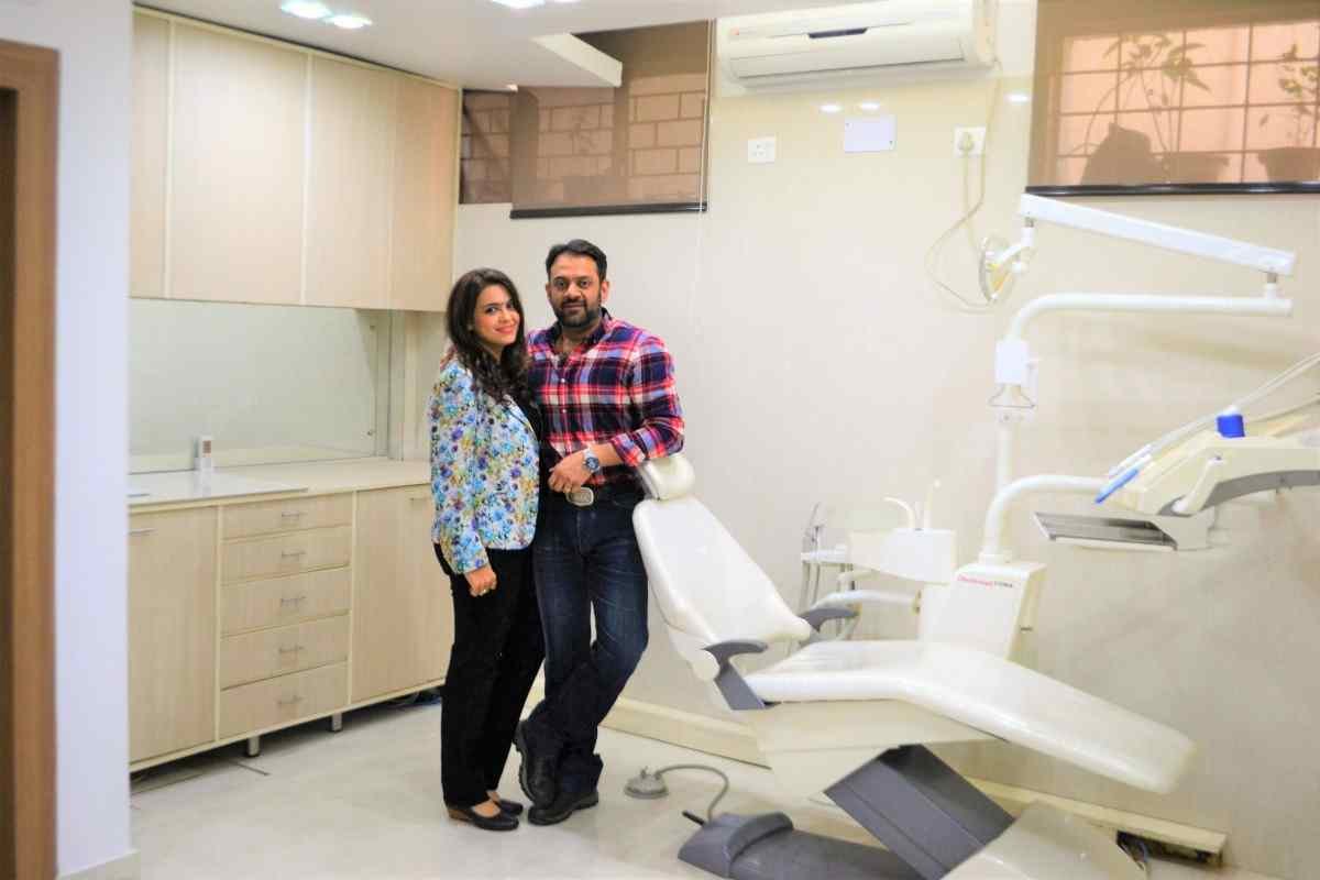 Dental World Punjabi Bagh clinic waiting area with black leather sofa and reception desk
