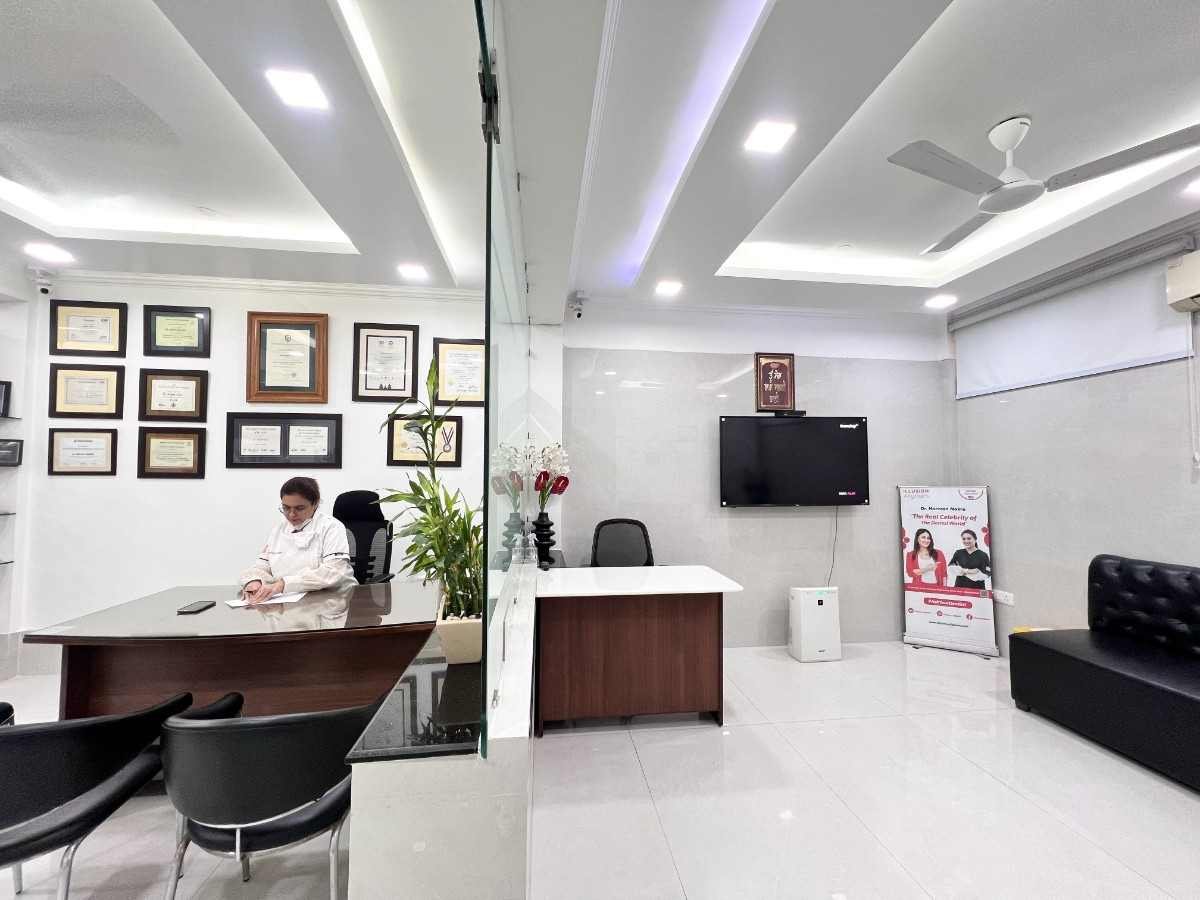 Doctor's consultation room with framed certificates, reception desk and patient seating at Dental World